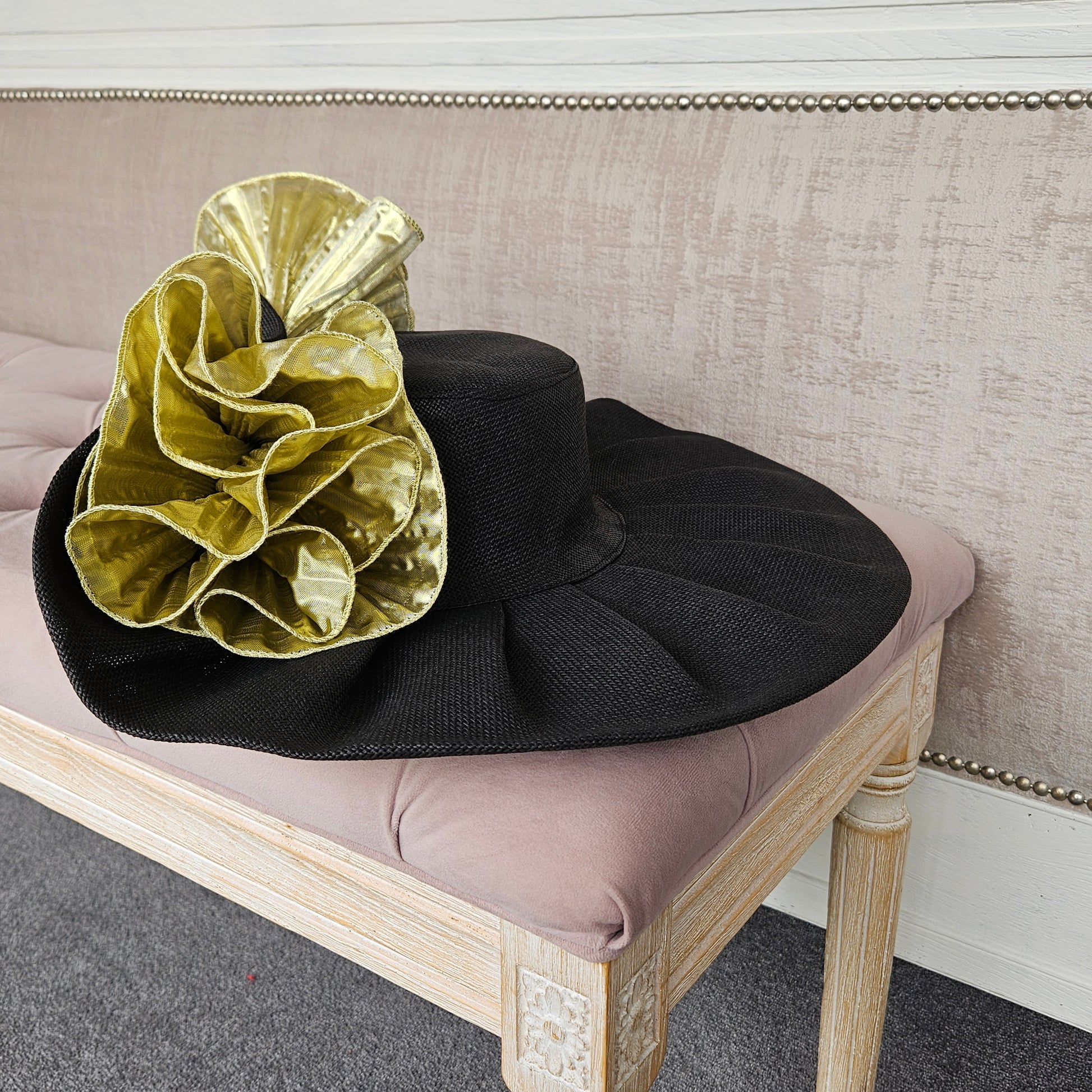Extra large black gold formal occasion hat for a wedding guest