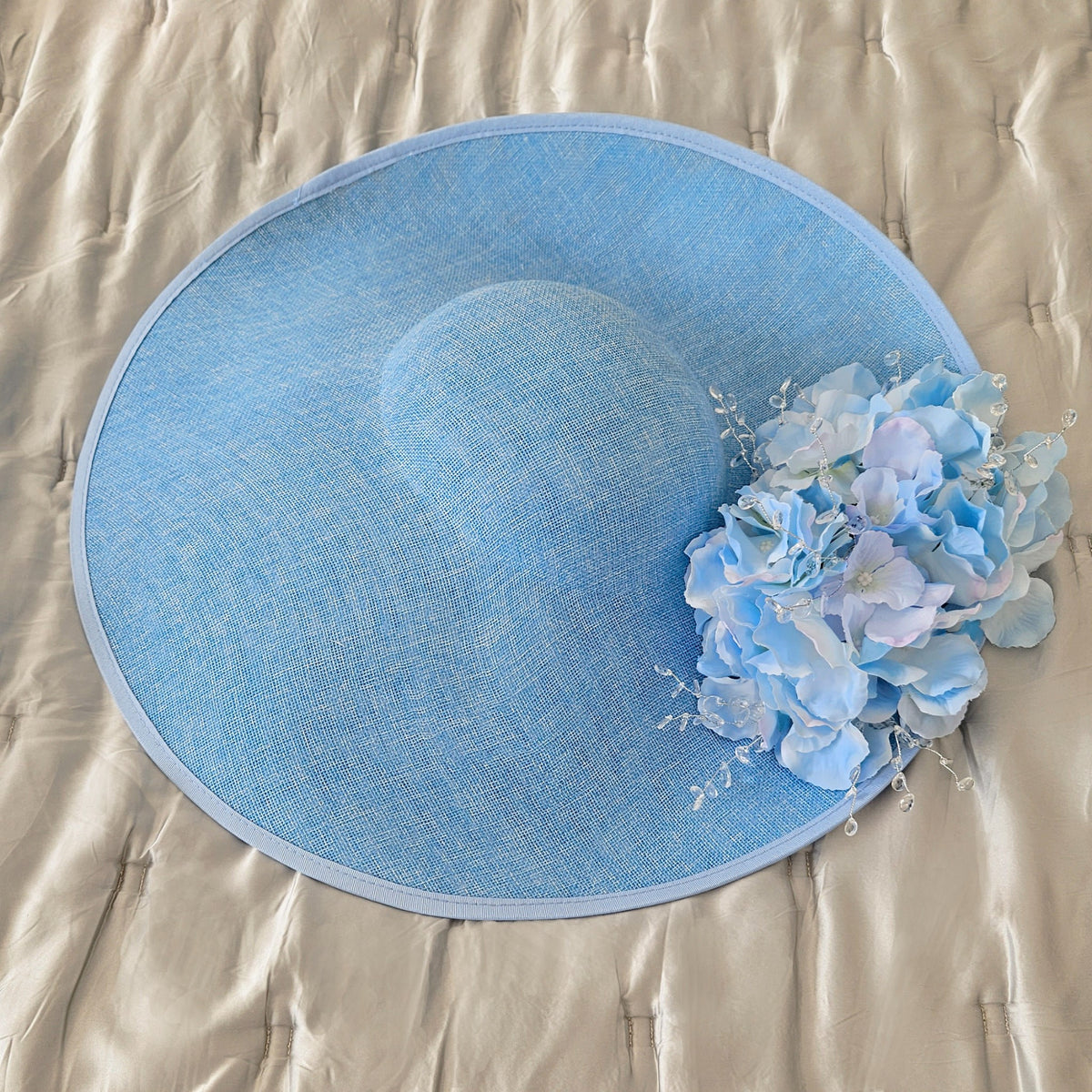 blue hat with flowers / hatinator for the Henley Royal regatta, the Melbourne Cup, spring racing, the Caulfield Cup, the Cox Plate, Dubai World Cup, the Preakness Stakes, the Belmont Stakes